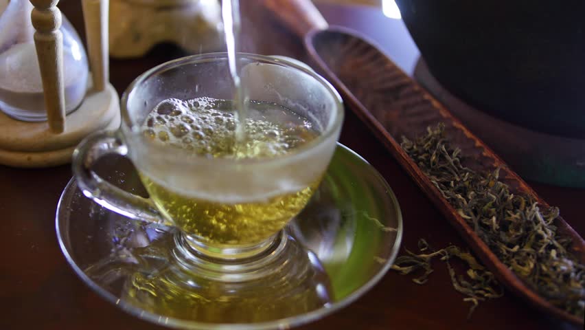 Pouring green tea into a beautiful glass cup | Shutterstock HD Video #3392188725