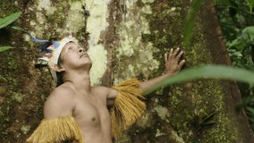 clips of an indigenous guy wearing a feathered hat and fringed shirt in the dense forest in Amazon, Leticia, Colombia
