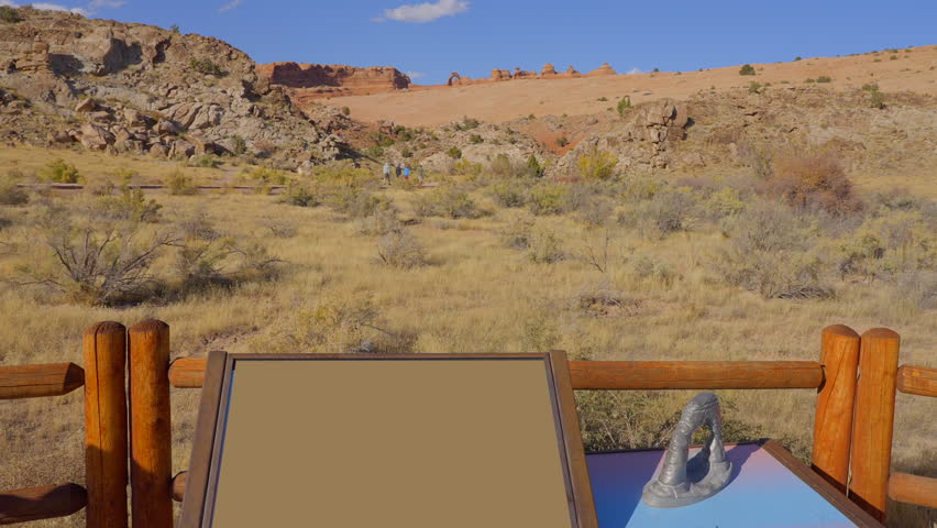 Establishing shot of mountain trail with red rocks background in Delicate Arch, Arches National Park, Utah, North America. Day time on October 2023. Still camera view. ProRes 422 HQ.