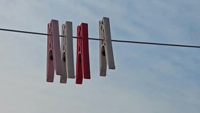 close up view of clothespins  on a rope against cloudy sky