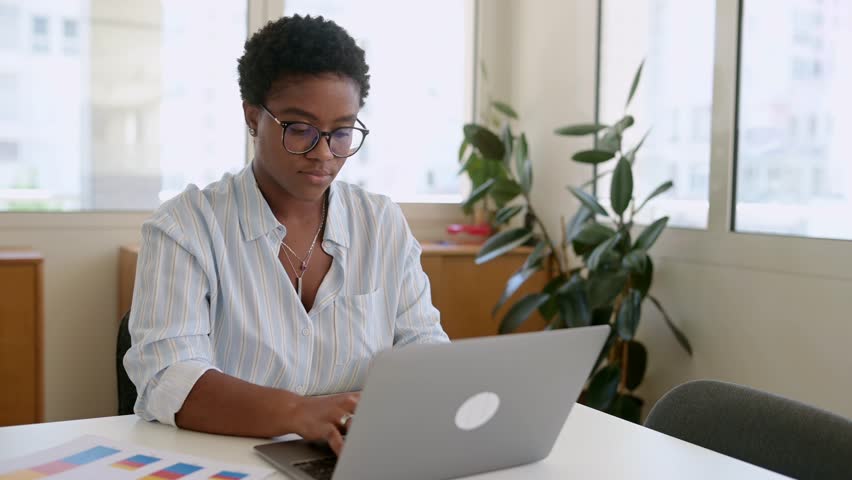 Frustrated african-american businesswoman worrying about project, sitting at the desk in front of laptop, depressed female employee feeling stress by mistake or unexpected computer error crash Royalty-Free Stock Footage #3392246579