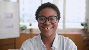 Portrait of confident African-American female employee with short hair standing in modern office space, cheerful attractive inspired black businesswoman looking at camera with light friendly smile - Powered by Shutterstock - Get 15% off with code: PIKWIZARD15
