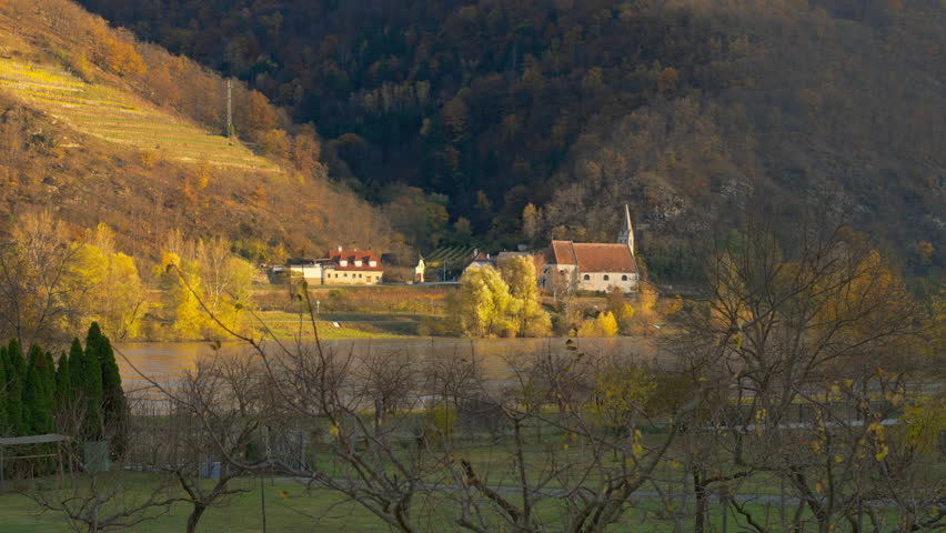Old historic church, St. Johan Mauerthale, sitting on the banks of the Danube River next to the hillside on a picturesque autumn day, Wachau Valley, Austria