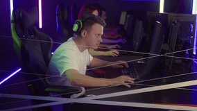 Player Rages After Facing Challenge At Video Gaming Tournament. Player Removes His Gaming Headset In Frustration. Player Reacts To Challenging Moment In Video Game. Competitive E-Sports Challenge