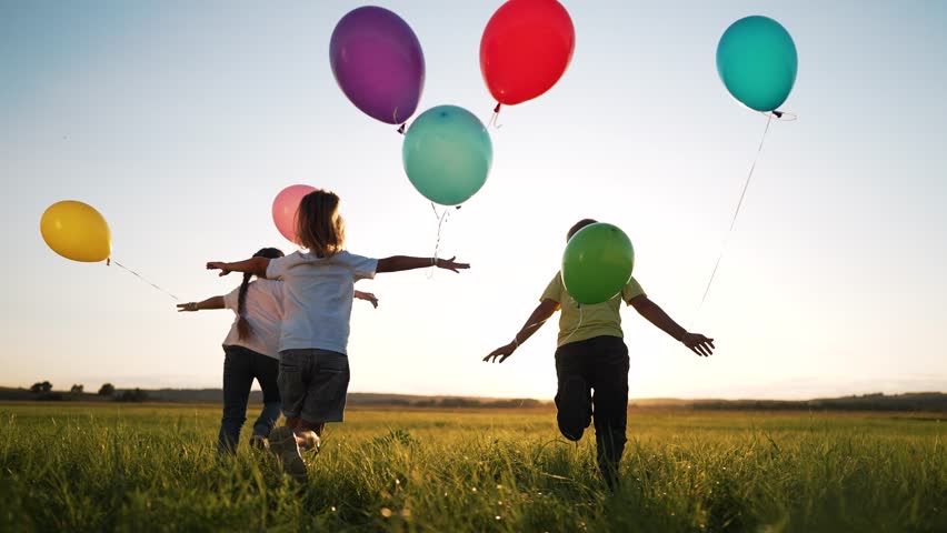 Happy family concept.Child run together and play in nature in summer with balloons.Balloons at sunset, celebration of summer freedom in hand of child.Kids run and play with colorful balloons in park Royalty-Free Stock Footage #3392404607
