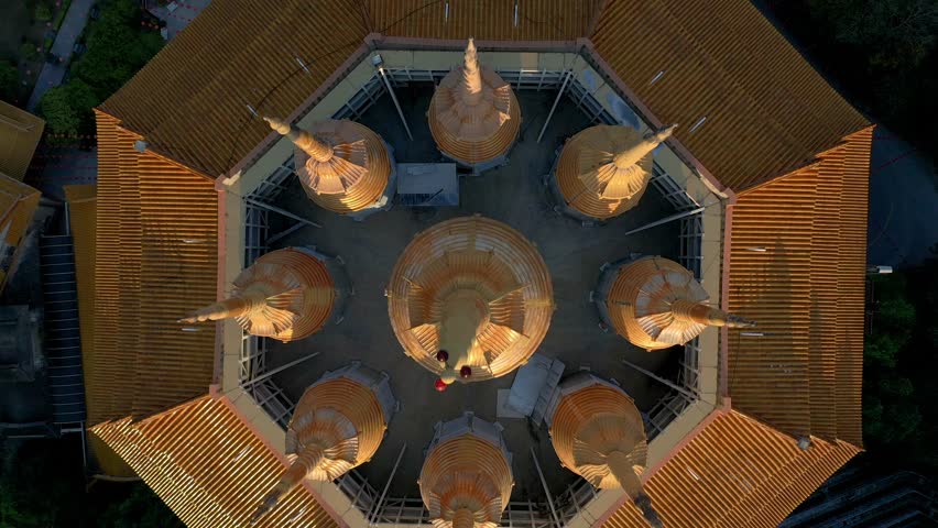 Drone shot looking down, flying back and tilting up over the pagoda at Kek Lok Si Temple on the island of Penang at sunset.
