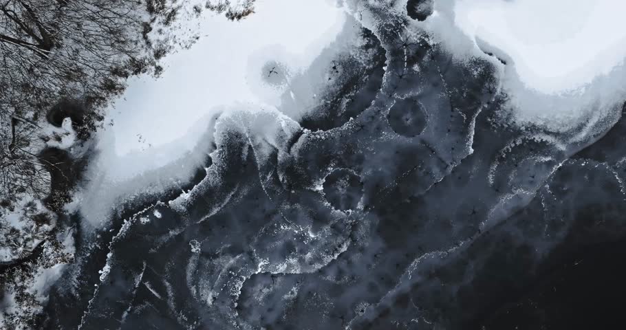 Ice holes, pier and boats. Winter hobby. Sport on frozen lake. Aerial view nature in Poland