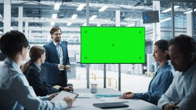 Electronics Factory Office Meeting: Caucasian Male Project Manager Presenting Innovative High-Tech Device On TV With Green Screen Chromakey. Diverse Engineers And Technicians Listening, Taking Notes. - Powered by Shutterstock - Get 15% off with code: PIKWIZARD15