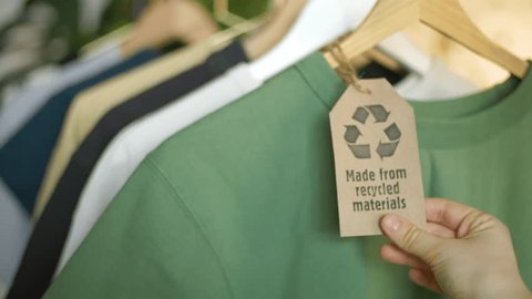  clothes made of recycled and upcycled materials. colorful organic t shirts on hangers, recycled cotton. sustainable fashion concept, eco fashion. environmental problems, small businessの動画素材