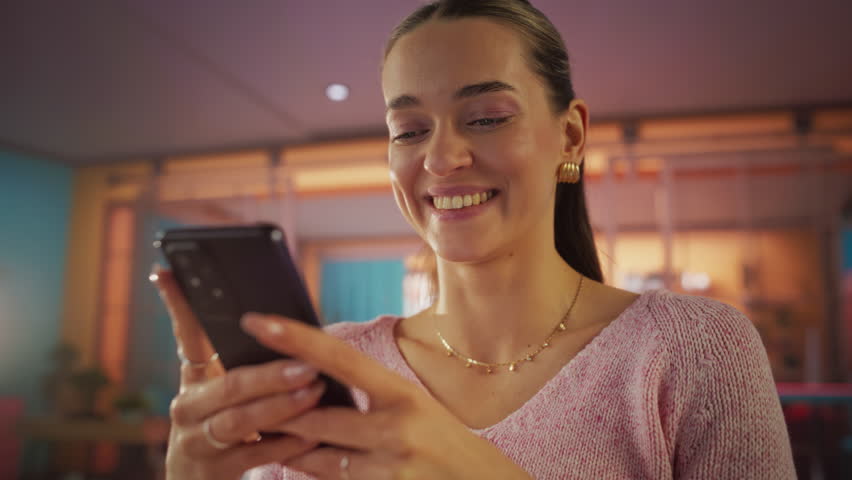 Slow Motion Portrait of Young Beautiful Female in Living Room, Resting and Using Smartphone. Creative Girl Checking Social Media, Chatting with Friends, Browsing Internet for Funny Videos