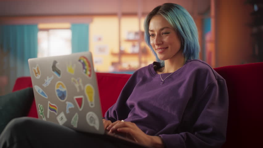Young Attractive Woman Working from Home on Laptop Computer with Stickers in Cozy Stylish Loft Apartment. Creative Female Smiling, Checking Social Media, Browsing Internet