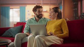 Portrait of Young Couple Using Laptop Computer While Sitting on Couch at Home. Boyfriend and Girlfriend Doing Online Shopping to Renovate the House, Browsing the Internet to Compare Sales. Slow Motion - Powered by Shutterstock - Get 15% off with code: PIKWIZARD15