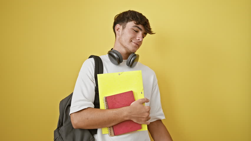 Confident young hispanic student, a patriotic lad holding his cuban flag and books isolated on vibrant yellow backdrop! Royalty-Free Stock Footage #3392704327