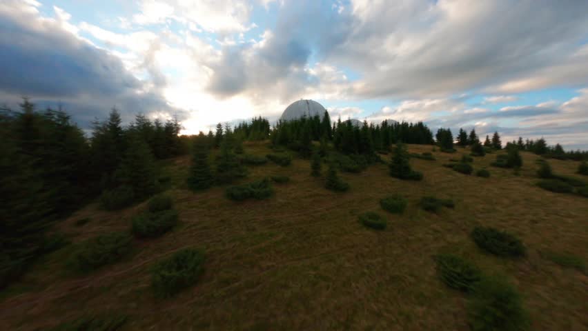FPV, Abandoned radar station Pamir in Carpathian mountains, research station on top of the mountain in the Carpathians in Ukraine. large white balloons designs in the mountains among the fir trees
