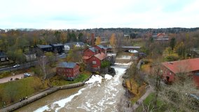 4K drone video of river flowing in coastal town of Helsinki Finland. Video also shows wooden houses and bridge during Autumn season 