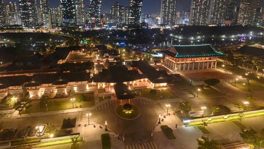 Time lapse of Skyscraper building illumination with car driving in traditional hotel at Songdo Central Park, Incheon, South Korea