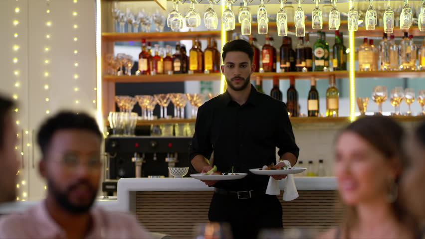 Couple of friends, restaurant and waiter with food for dinner, fine dining and date night in hospitality services. Young group of people and worker giving plate at tablet for happy customer service