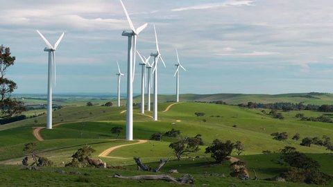 Multiple wind turbines spinning in Australian farmland.