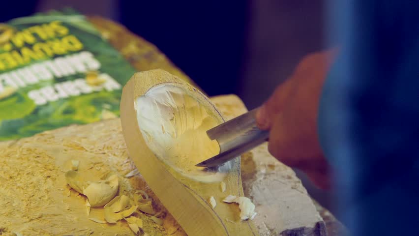 Hand Held Close Up Shot of Carpenter Showing Apprentice How to Carve a Wooden Spoon Royalty-Free Stock Footage #3392933511