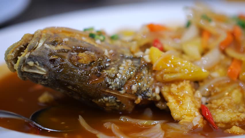 Homemade sweet and sour carp served on a white plate. The giant gourami (Osphronemus goramy) is a species of large gourami native to freshwater habitats in Southeast Asia. Selective focus
