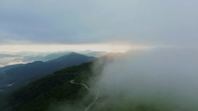 Mountain and forest landscape with clouds with aerial view from drone. Fog clouds cover the mountains and forests.