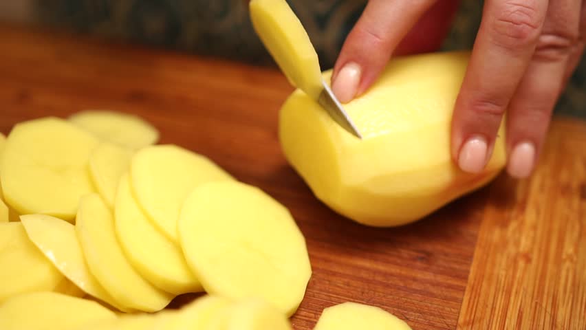 Slicing vegetables potato. Female hands cut carrot on a wooden cutting board. Cooking in the kitchen. Food preparation. Close-up. Royalty-Free Stock Footage #3393161861