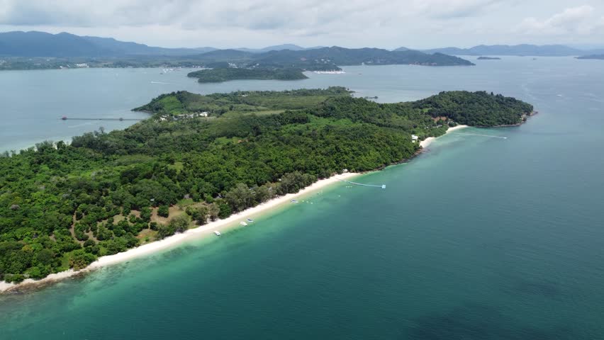 Aerial drone view of Ko Naka Yai a tropical island near the coast of Thailand Phuket showing the white beaches and trees and the mountains in the far background on mainland 4k high resolution quality Royalty-Free Stock Footage #3393255075