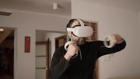 Man At Home Wearing Virtual Reality Headset Holding Gaming Controllers. Active VR Game Virtual Reality Technology Gaming Simulation Helmets. Person Fight Boxing AR Glasses. VR Technology