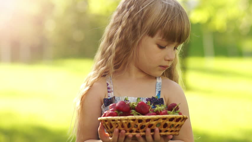 Portrait of a smiling child with a basket of strawberries
