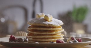 Sprinkling sugar powder on stack of delicious pancakes. No people, advertisement. Lifestyle, cooking and domestic life. Beautiful cinematic video social media aesthetics. Treat for eyes and taste bud