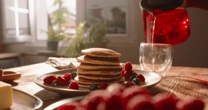 Elegant process of pouring tea during breakfast homemade pancakes with berries. No people, advertising, cinematic. Yummy delicious gluten-free food options dessert cheat meal, tasty but dangerous food