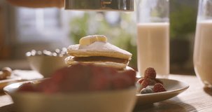 Unrecognizable chef aesthetically decorats stack of perfect pancakes with powdered sugar and sprig of mint. Advertising cinematic. Leisurely cozy morning, relax and relish in gluten-free breakfast