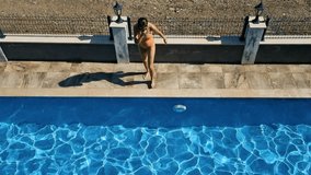 Woman jumping to the pool. 4k video footage UHD 3840x2160
