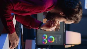 Vertical video Happy videographer reviewing footage and selecting scenes, trimming them using specialized software applications and editing tools. Smiling video editor working for media company in - Powered by Shutterstock - Get 15% off with code: PIKWIZARD15