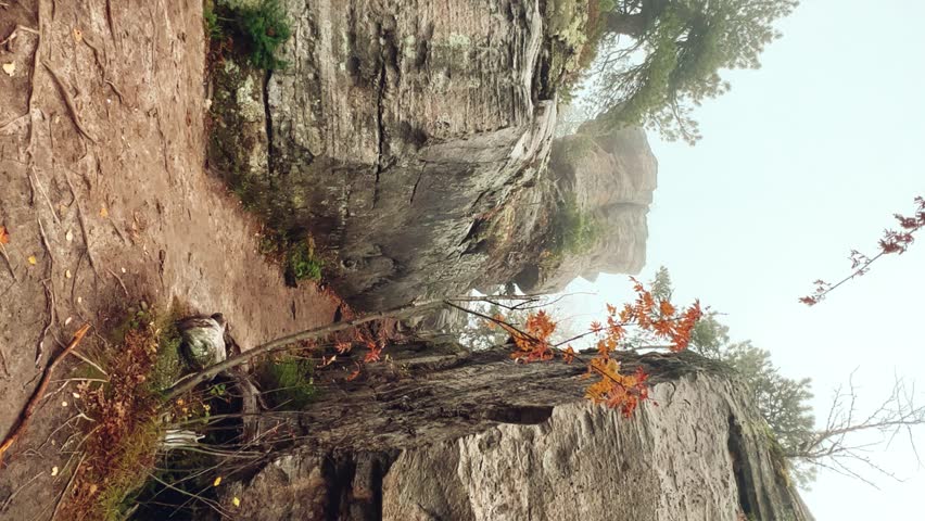 Stone City in autumn. Bright foliage and autumn landscape. The natural landscape is a rock formation in Central Russia, the Urals. A natural monument. Ancient rocky folding in the Ural Mountains. 4K