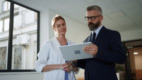 Pharmaceutical sales representative talking with doctor in medical building. Hospital director consulting with healthcare staff. - Powered by Shutterstock - Get 15% off with code: PIKWIZARD15