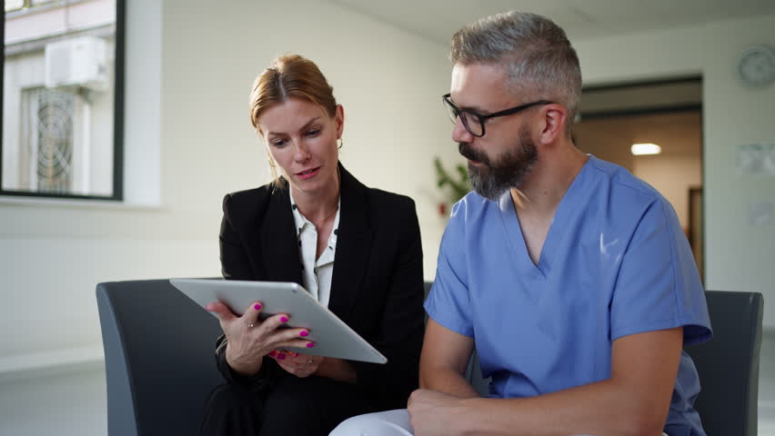 Pharmaceutical sales representative talking with doctor in medical building. Ambitious hospital director consulting with healtcare staff. Woman business leader.