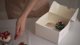 woman preparing cake and pastries. putting pastries in a box. putting muffins in a box. slow motion video. High quality 4K footage