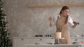 woman prepares cake and pastries. woman dancing in the kitchen. slow-motion video. woman and cake. High-quality shooting in 4K format