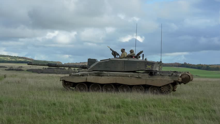 Close-up of a British army Challenger 2 II FV4034 main battle tank in action, scoping for targets on a military exercise, Commander and gunner atop. Wilts UK