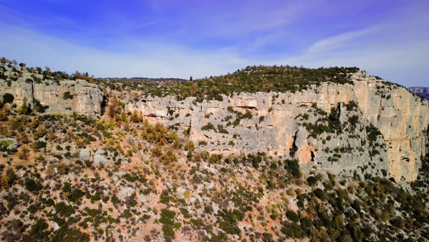Canyon cliffs in green forest, panoramic mountain view. Sheer canyon, cliff landscape with wild forest backdrop, showcasing travel. Canyon, cliff scenery, majestic mountain range, natural beauty