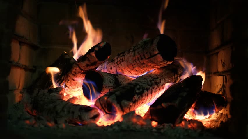 A fireplace with burning logs. Fire in the fireplace. A cozy place to rest. Fire and firewood as background. Burning wood in the furnace. Fire video Royalty-Free Stock Footage #3394072483