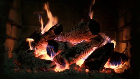 A fireplace with burning logs. Fire in the fireplace. A cozy place to rest. Fire and firewood as background. Burning wood in the furnace. Fire video