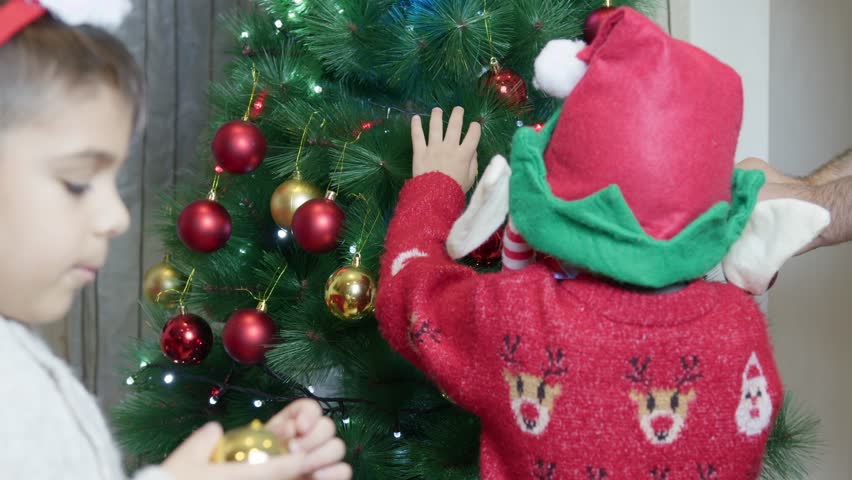 Cute brothers decorating christmas tree. Children waving to camera. Slow motion. High quality 4k footage