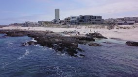4K high quality aerial video view of Western Cape's coast, Bloubergstrand sandy beach, sea birds flying around and view of Table Mountain in the background in Cape Town, South Africa on sunny morning