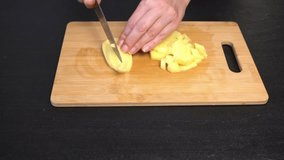 Cutting fresh potatoes into slices and cubes. Close-up. Slowmotion video. Home cooking. Cooking master class. Step-by-step video recipe for making borscht.