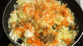 Cabbage is stewed with carrots and black pepper in a frying pan. TView from above. Cooking master class. Step-by-step video recipe for making stewed cabbage.