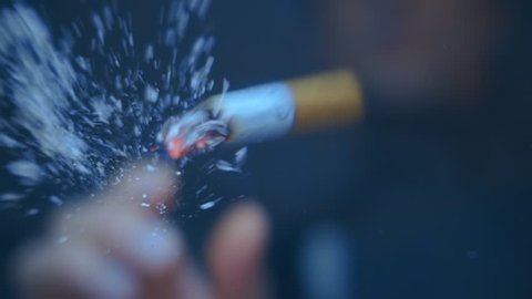 The man throws a cigarette into the camera, the ashes fly from the impact about the protective glass. Closeup. Slow mo, slo mo, slow motion, high speed camera, 240fps, 250fps