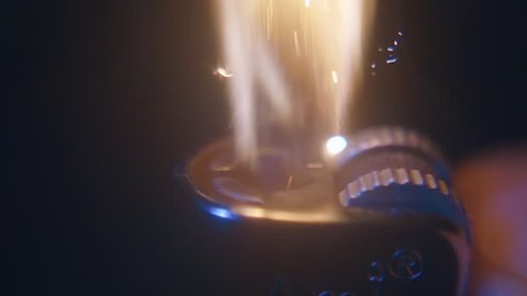 Ignite a cigarette lighter in the hand with a lot of sparks are flying out on black background. Closeup. Slow mo, slo mo, slow motion, high speed camera, 240fps, 250fps