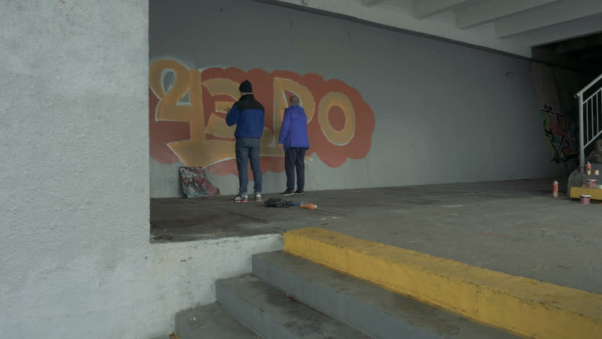 Graffiti. A young guy draws on the wall.